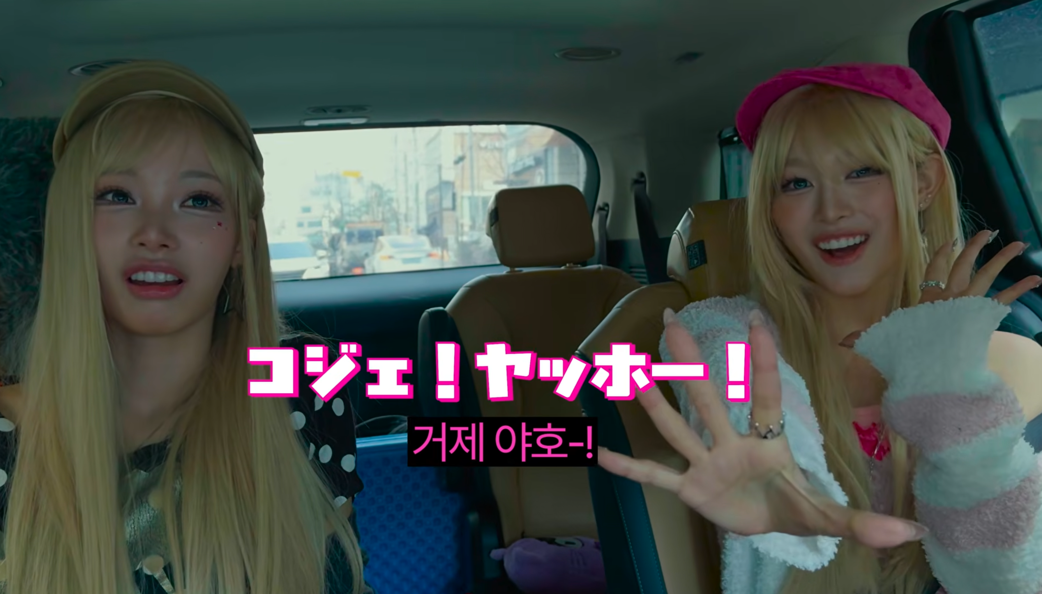 A cheerful person on a scenic island viewpoint throwing both arms up and shouting "야호!" with a huge smile, text "야호 (yaho) = woohoo!" on screen